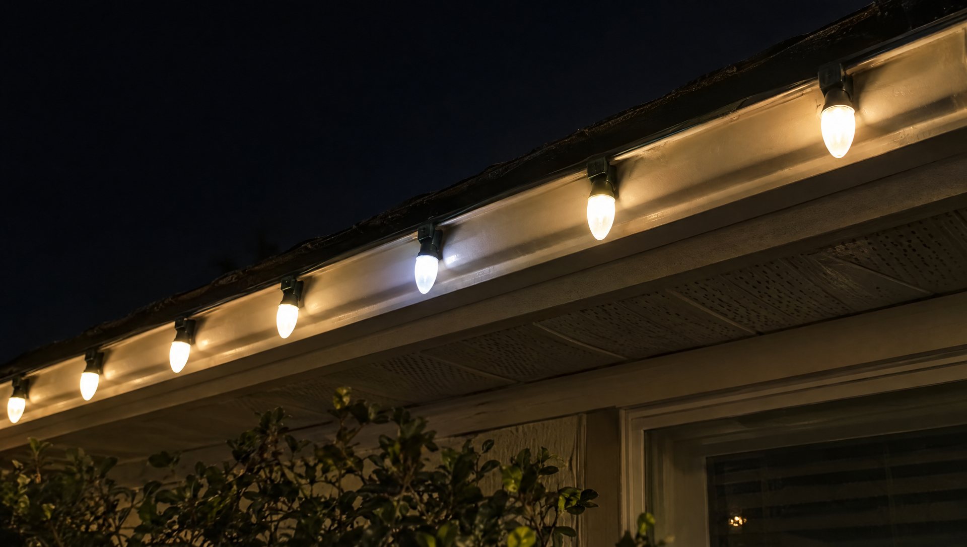 Warm white LED C9 bulbs on a gutter at night with one bulb a slightly different tone