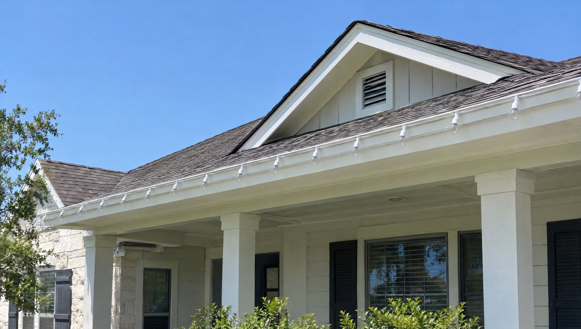 Unlit C9 roofline bulbs in daylight with white wire matched to trim on an Austin home