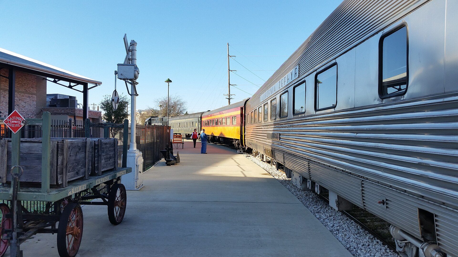 The historic Cedar Park rail depot with the silver passenger car Silver Pine parked in front