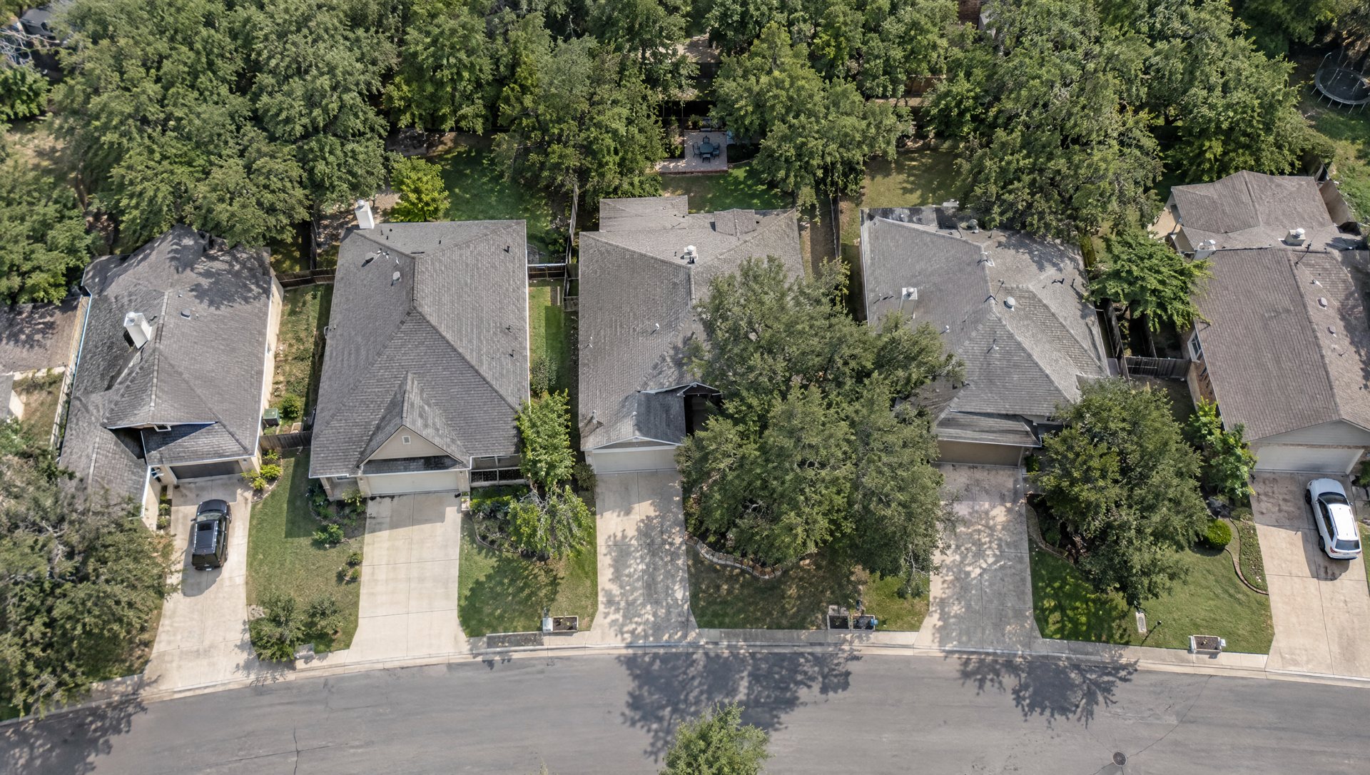 Aerial view of Austin-area rooftops and driveways, the kind of image installers measure rooflines from.