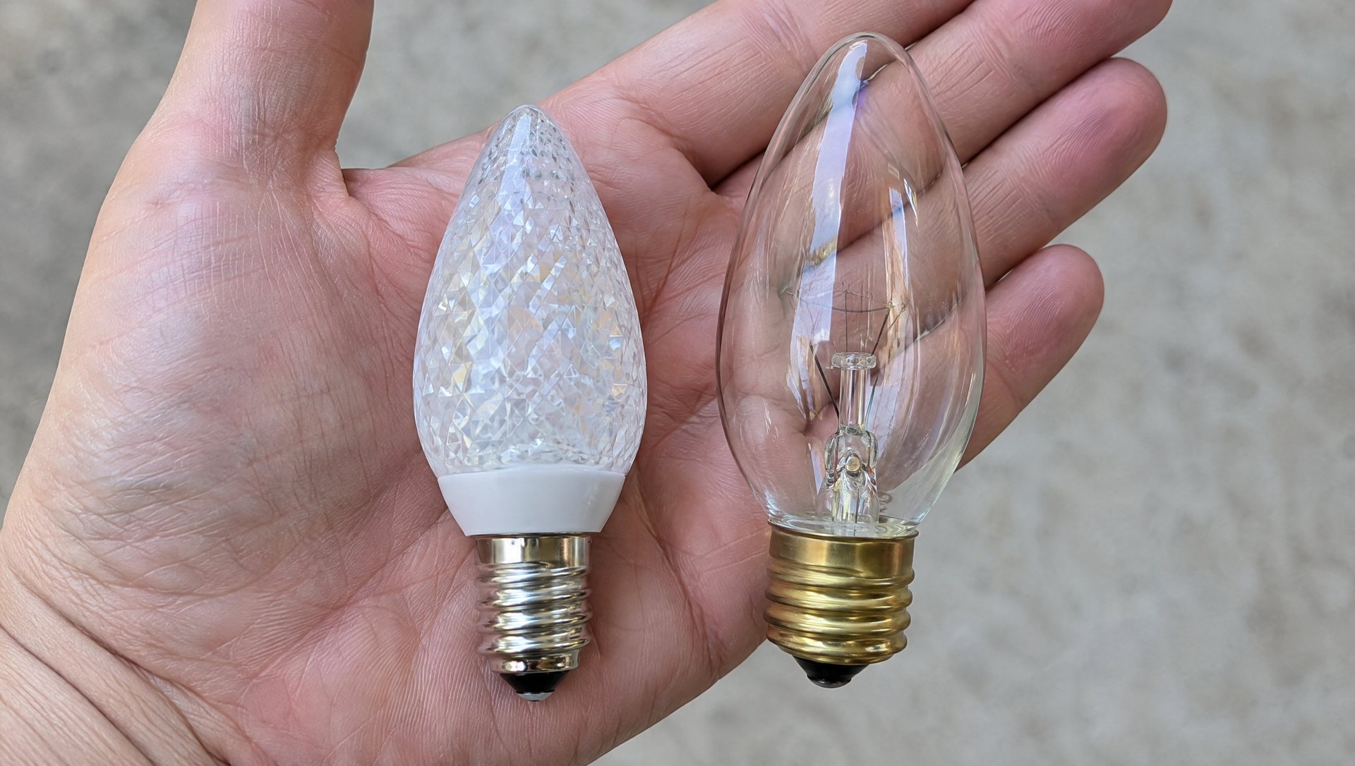 LED and incandescent C9 Christmas bulbs held side by side for comparison