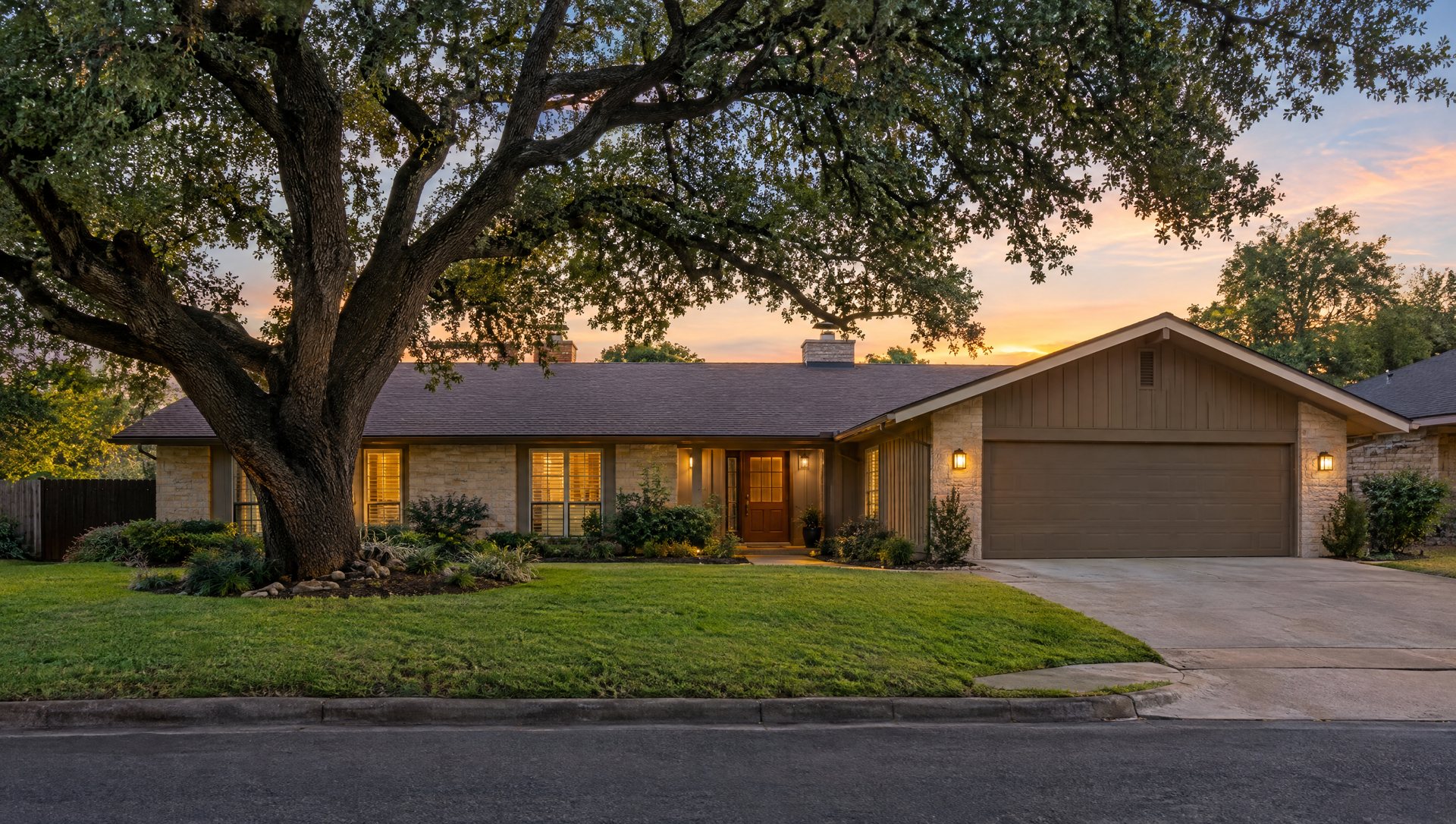 Austin ranch home with a C9 Christmas light roofline glowing in early evening