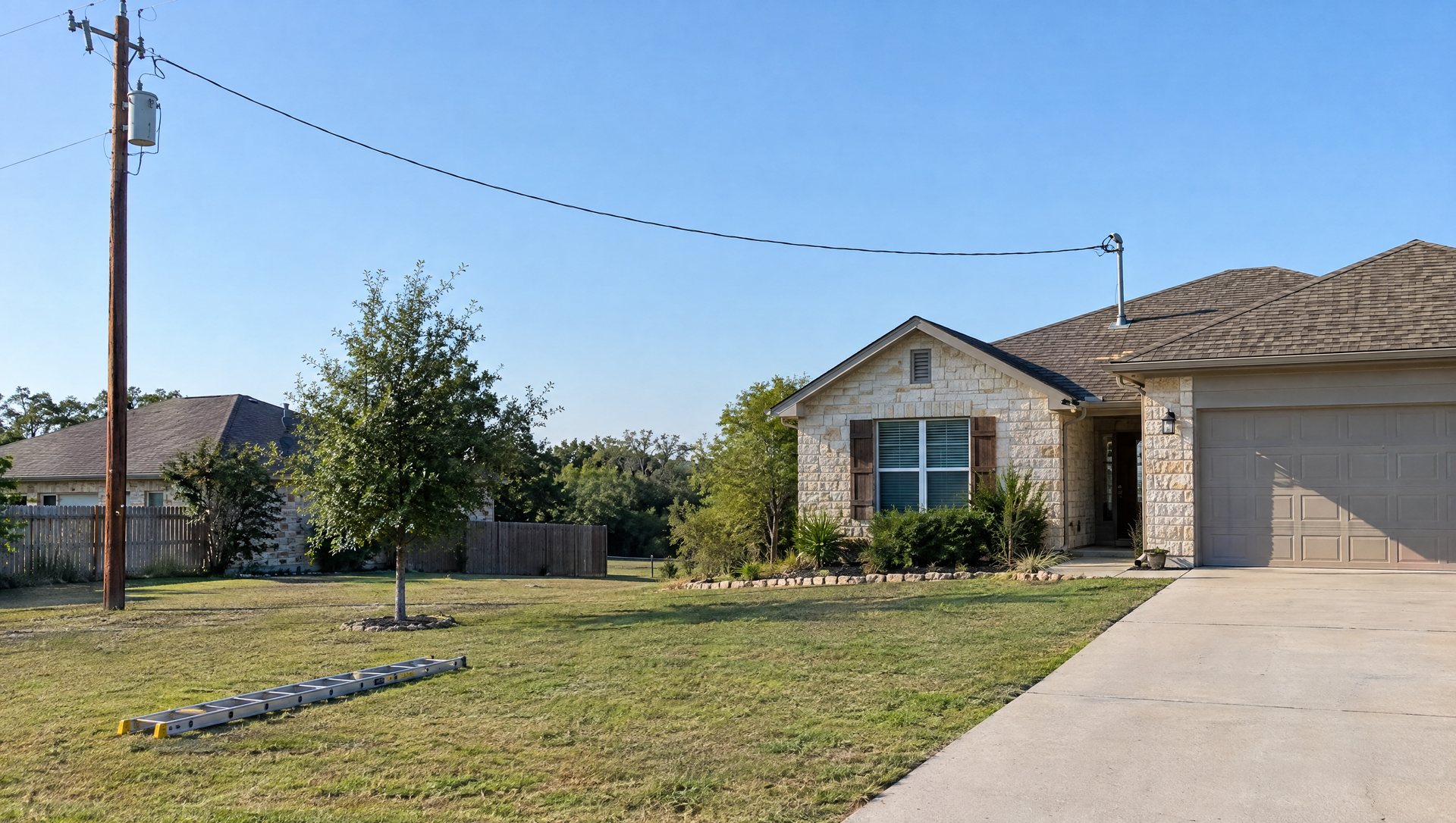 Fiberglass ladder lying on a lawn away from the overhead service cable running to a house