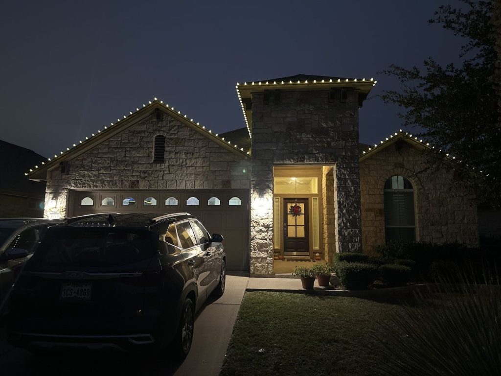 Stone home with a tower entry and a warm white roofline