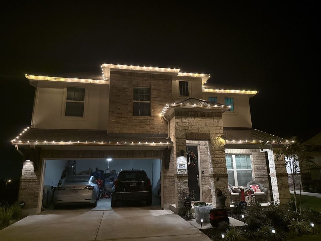 Two-story home with a warm white roofline at night