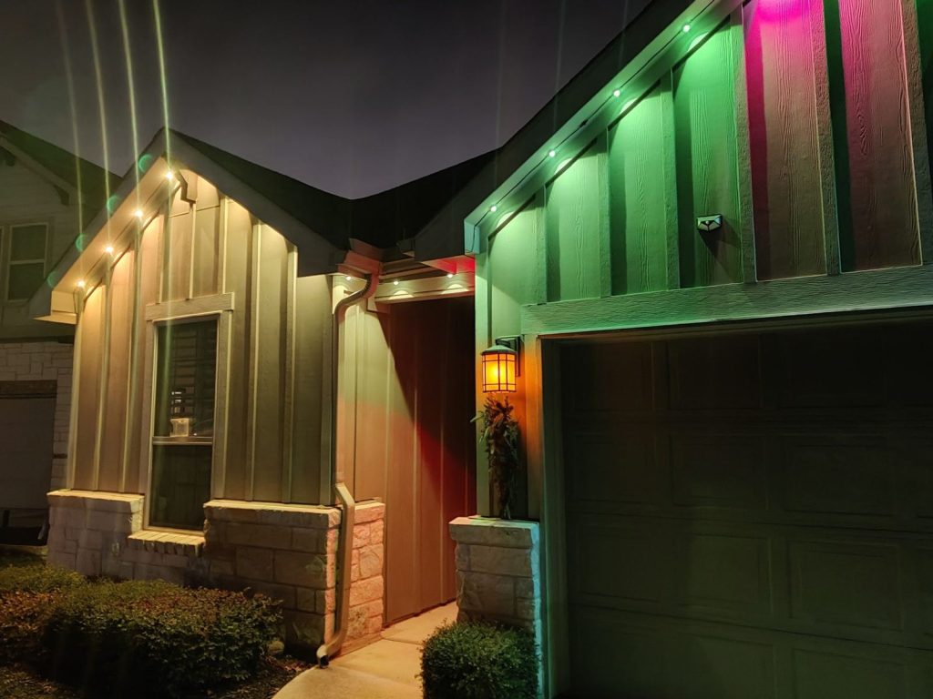 Board-and-batten home with permanent eave lights in green, red and warm white