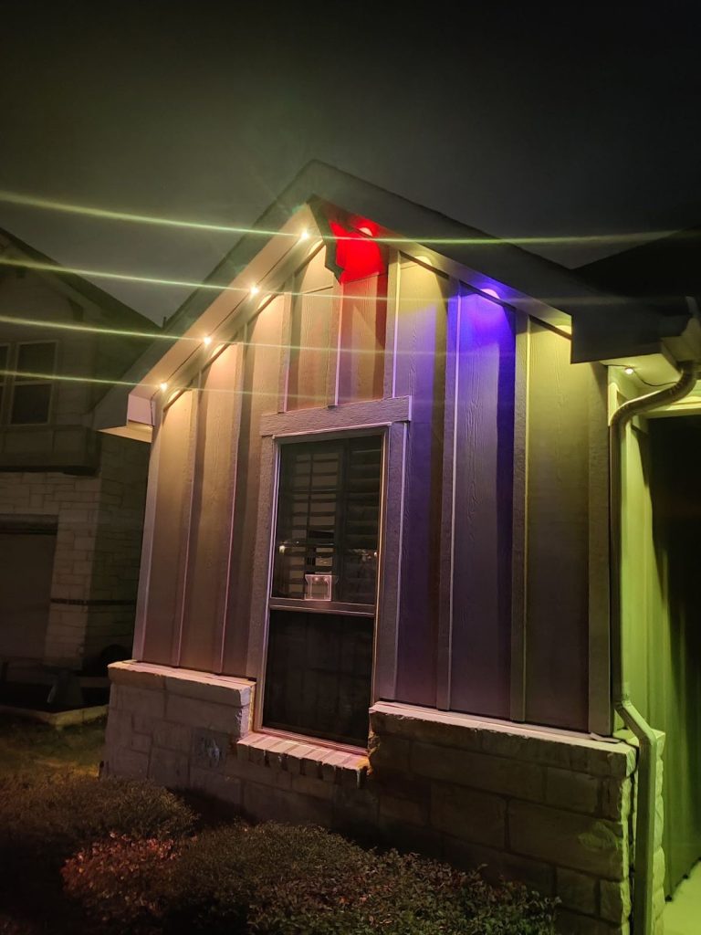 Board-and-batten gable with permanent eave lights in mixed colors