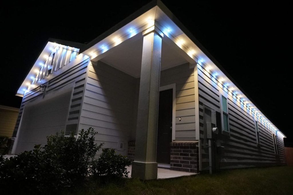 Modern home with permanent lights in cool white along the eaves and porch