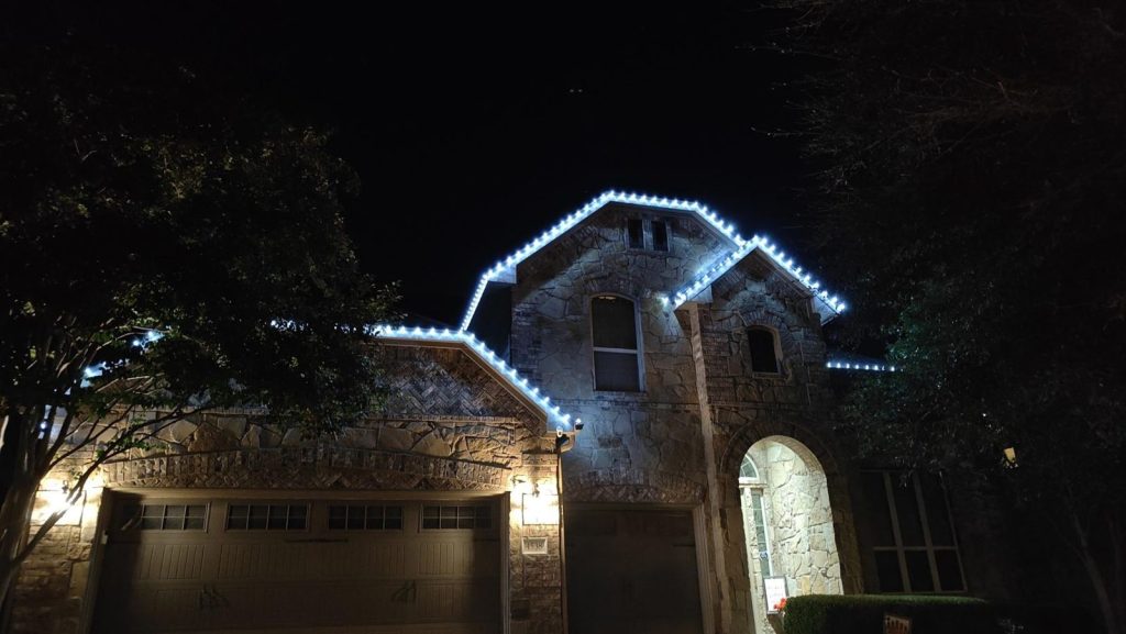 Stone home with permanent lights in cool white and blue