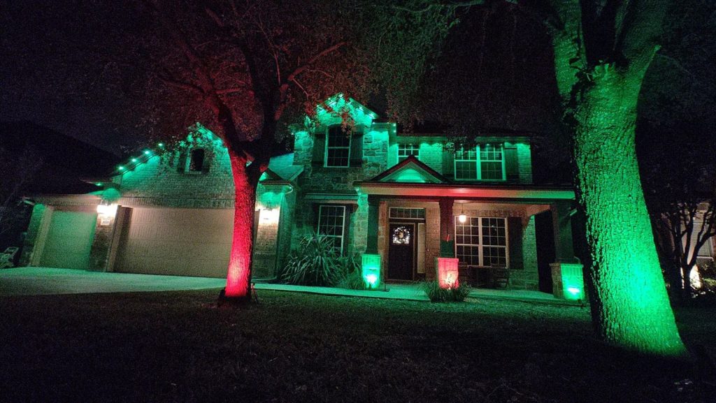 Green and red permanent eave lights with matching uplighting on the front-yard trees