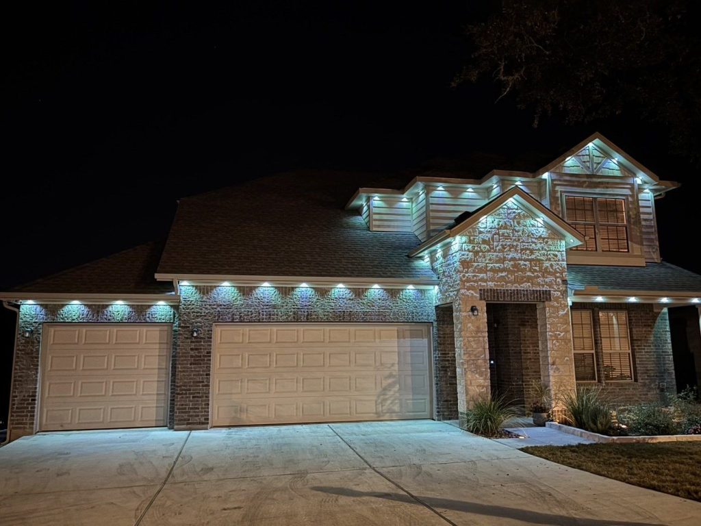 Two-story home with permanent lights in cool white across the eaves