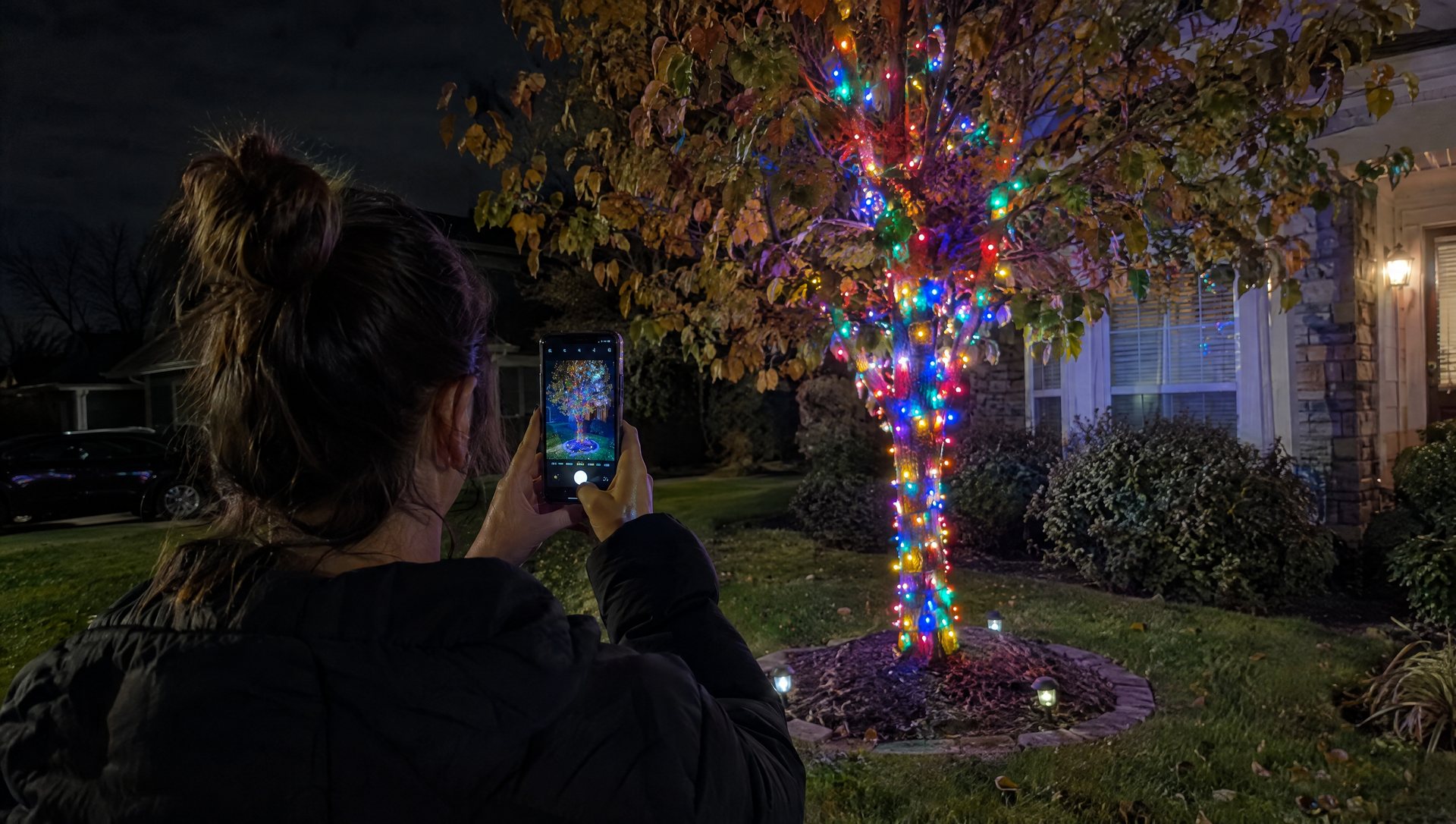 Phone camera mapping a smart Christmas light tree in a front yard at night