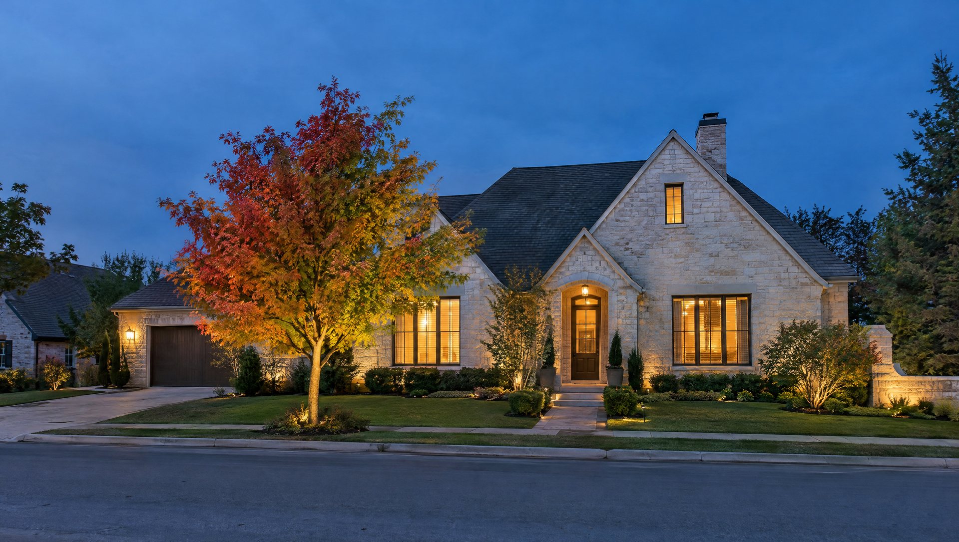Warm-white house outline with one color-changing smart-light tree at blue hour